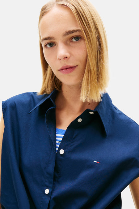 Chemise sans manches bleue de TOMMY JEANS, avec boutons blancs et un petit logo sur la poitrine.