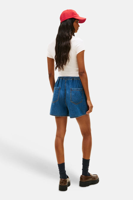 Mid-blue denim short van TOMMY JEANS, met elastische tailleband en opgestikte zakken, achterkantweergave.
