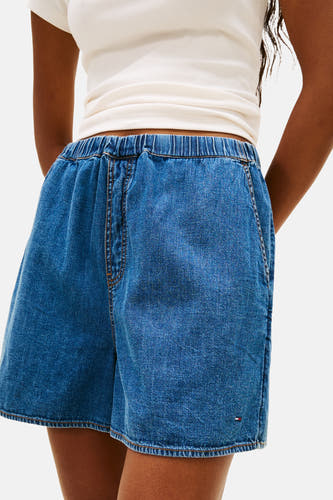 Korte mid blue denim short van TOMMY JEANS met elastische tailleband en logo detail.
