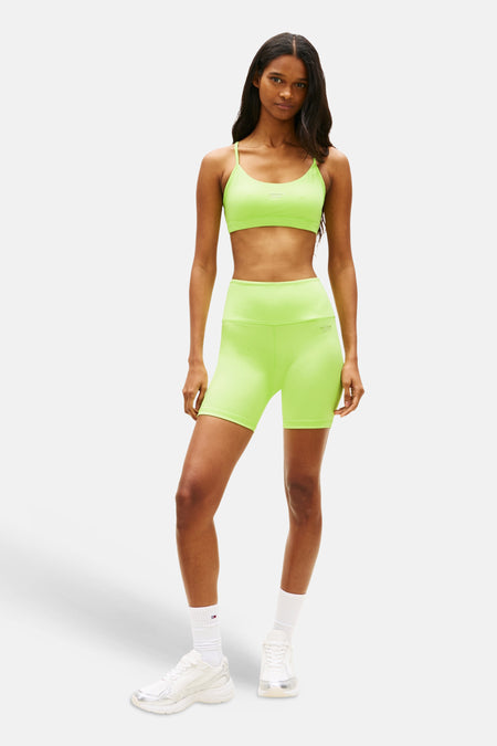 Groene short van TOMMY JEANS, gecombineerd met een bijpassende sporttop, witte sokken en sneakers.