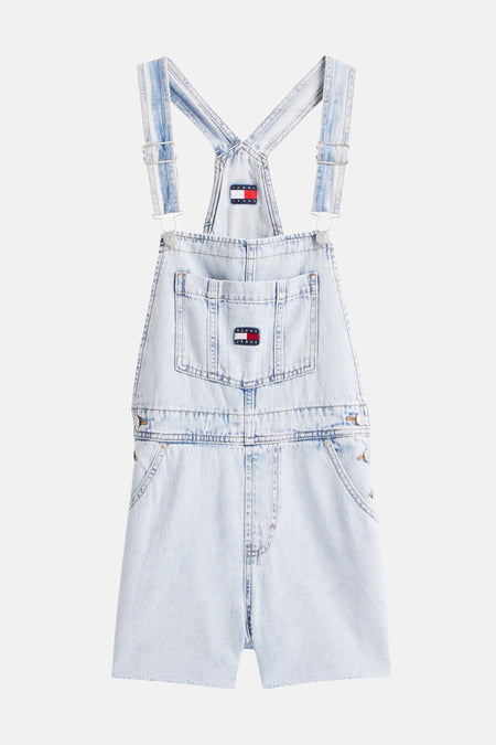 Combinaison en denim bleu clair de TOMMY JEANS avec bretelles réglables, poche poitrine et jambes effilochées.