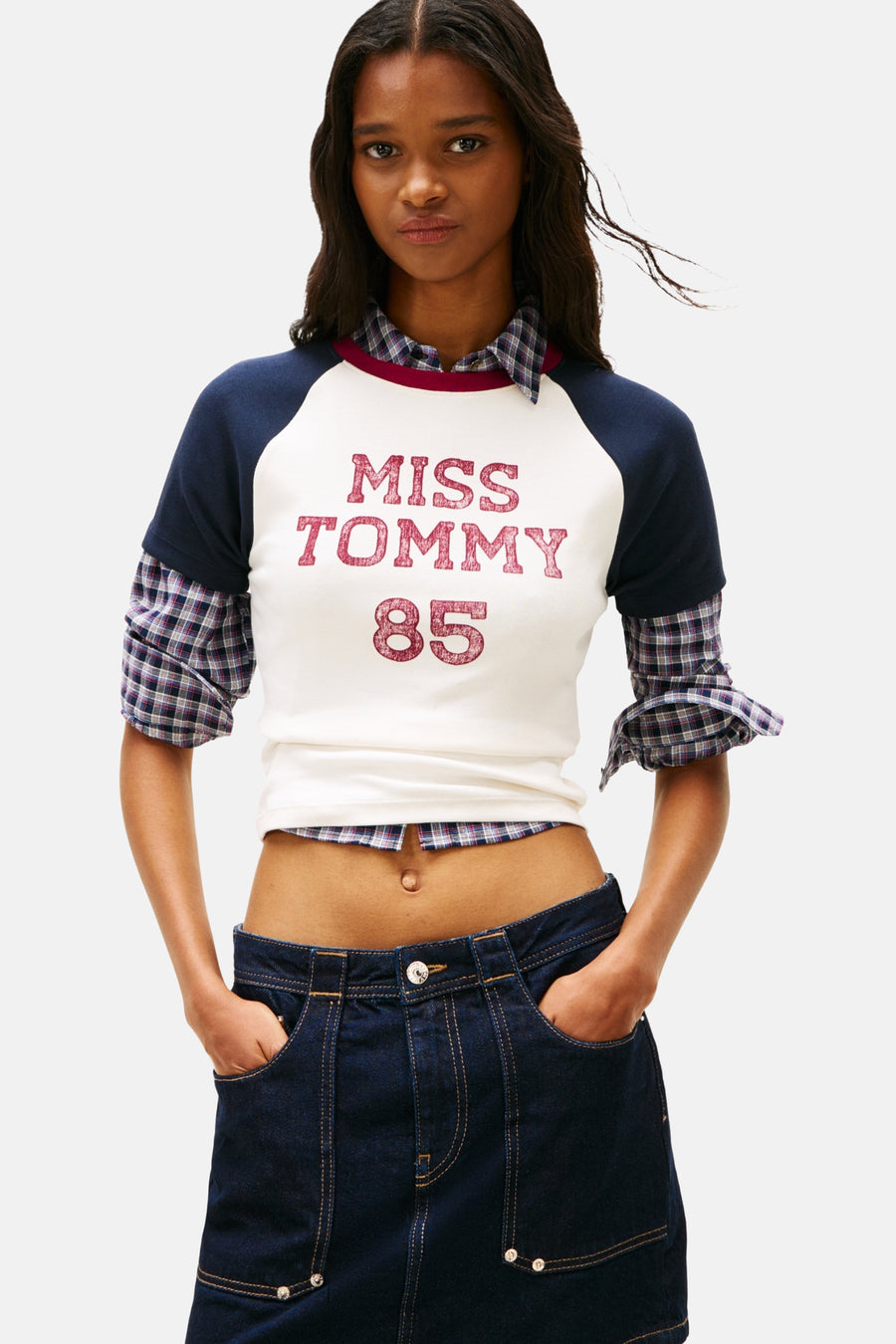 Multicolor T-shirt met korte mouwen van TOMMY JEANS, met een bedrukte tekst en gecombineerd met een geruit overhemd en denim rok.
