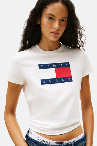 Wit T-shirt met korte mouwen van TOMMY JEANS, gedragen met een jeansbroek en ondergoed met het merklogo.

