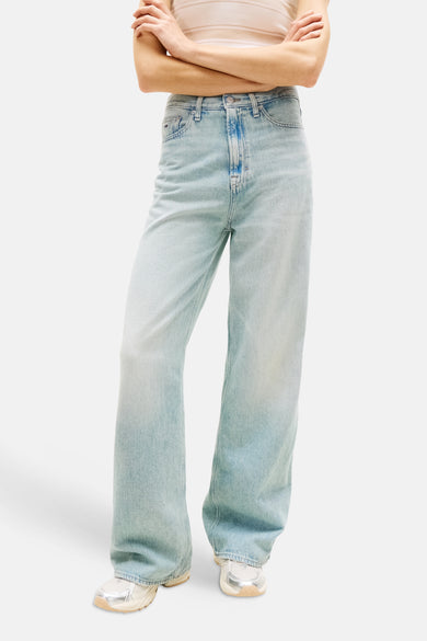 Wijde jeans van lichtblauw denim van TOMMY JEANS, met wijde pijpen en gedragen met sneakers.