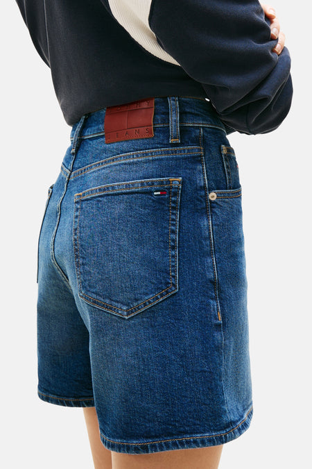 Short en jean denim bleu foncé de TOMMY JEANS, avec poches arrière et étiquette en cuir marron.