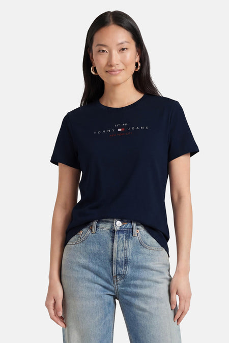 Donkerblauwe korte mouwen T-shirt van TOMMY JEANS met wit logo en rode tekst, gedragen met lichtblauwe jeans, front view