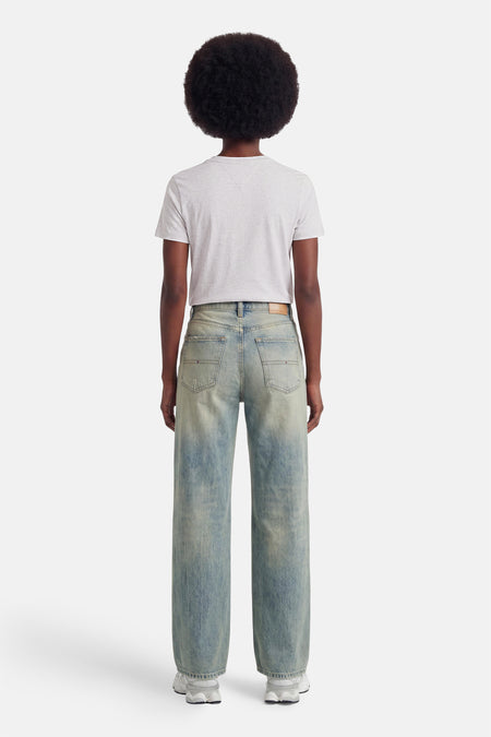 Grijze korte mouw T-shirt van TOMMY JEANS, rugzijde, met lichte textuur, gedragen met lichte jeans en witte sneakers