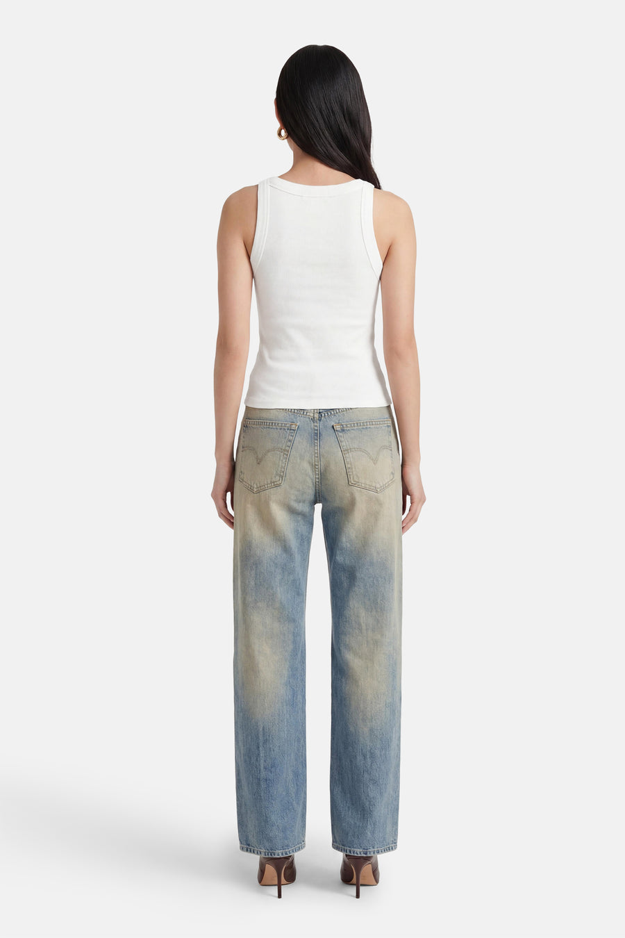 Witte ribbel tanktop van TOMMY JEANS, strak model, achterzijde, met lichtblauwe jeans en hoge hakken