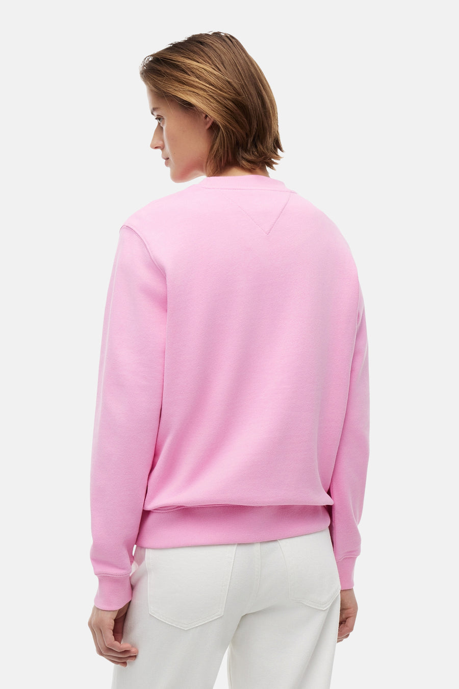 Pull rose de TOMMY JEANS, dos montré, avec subtile couture en V au col.