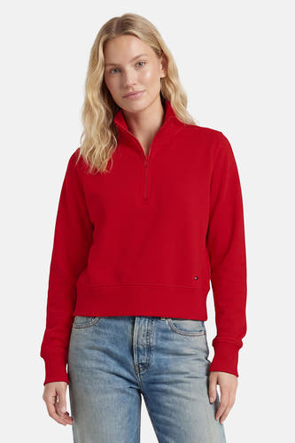 Rode sweater met halve rits van TOMMY JEANS, comfortabele pasvorm, ribboorden, klein logo op borst, model in lichtblauwe jeans, front view