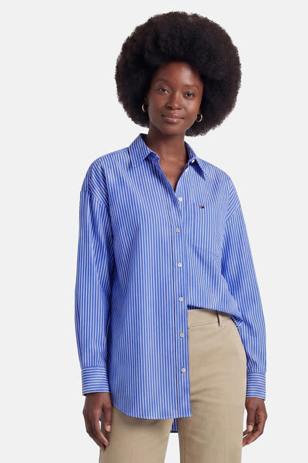 Blauw gestreept overhemd met lange mouwen van TOMMY JEANS, voorzien van borstzakje en witte knopen, gedragen met beige broek.