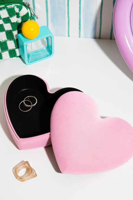 Roze hartvormige sieradenbox van fluweel, van THE WOW EFFECT COMPANY, met zwarte binnenkant en ringen, lifestyle-opstelling