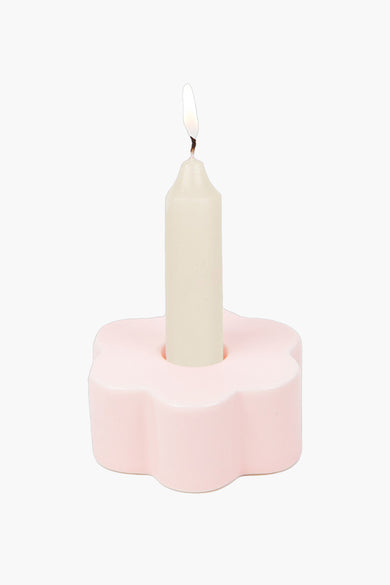 Roze bloemvormige kaarsenhouder van DOIY, met een brandende kaars erin, op een witte achtergrond.
