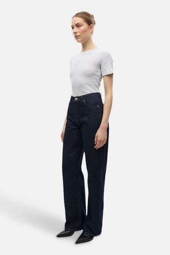 Jean droit bleu marine d'ENVII, avec une taille haute et porté avec un chemisier gris et des chaussures noires.