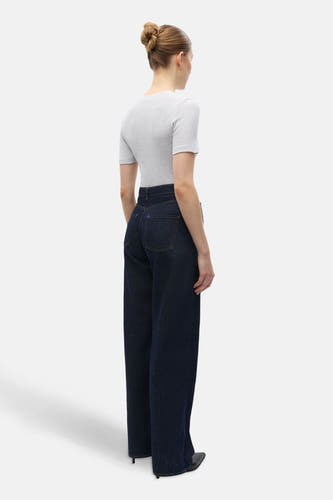 Jean droit bleu marine d'ENVII, vu de derrière, associé à un t-shirt gris et des baskets noires.