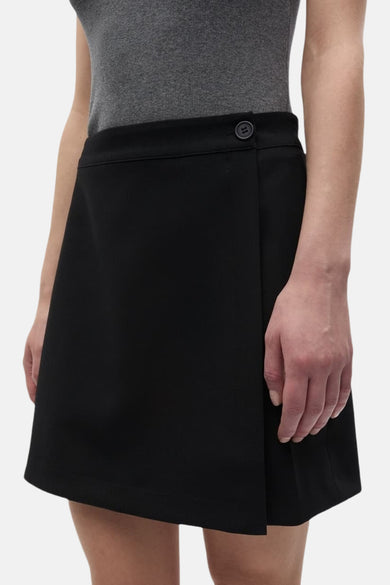 Zwarte korte rok van ENVII, met knoopdetail aan de bovenkant en een overslag design.
