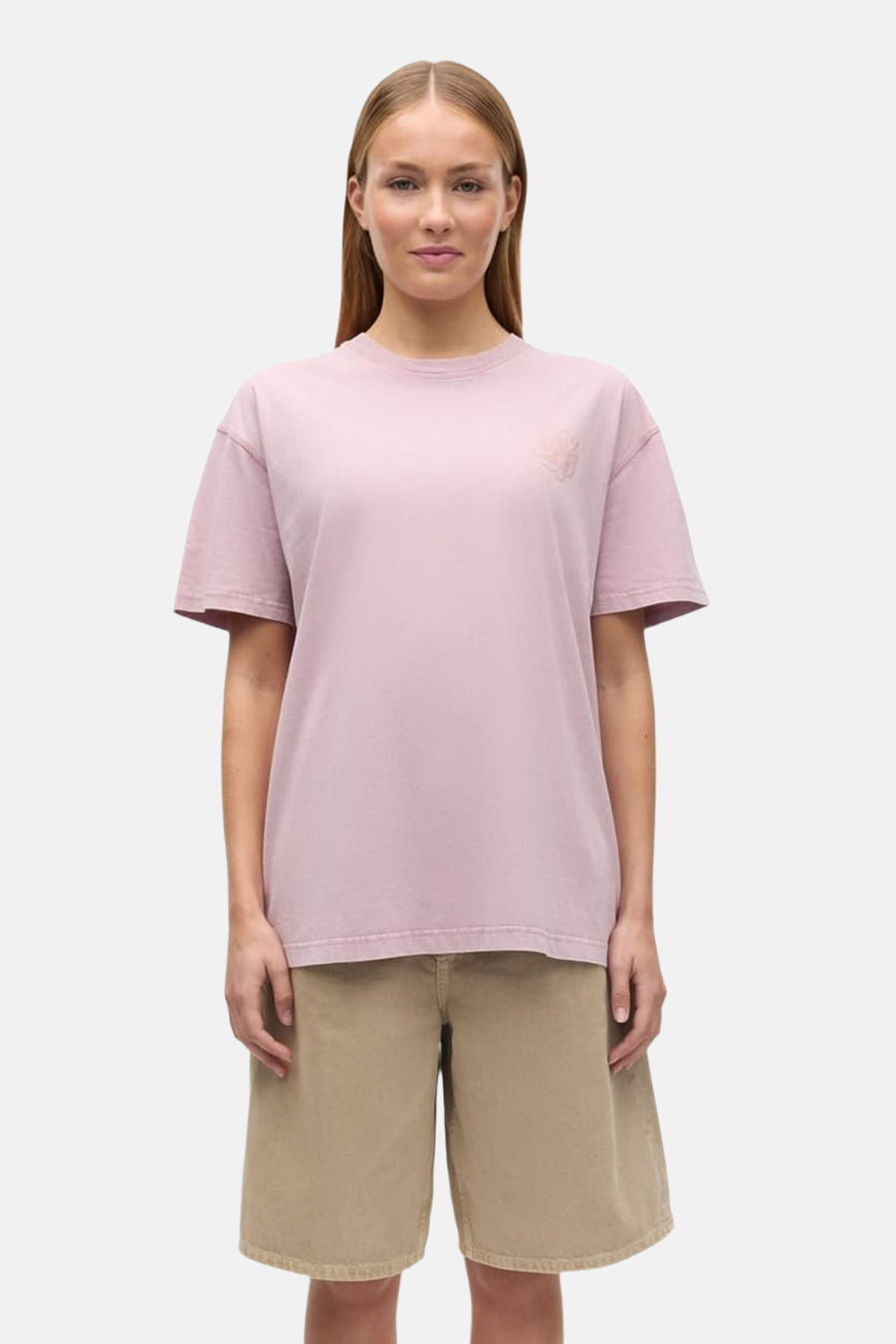 Roze T-shirt van ENVII met geborduurd logo op de borst, gedragen door een vrouw met een beige korte broek.