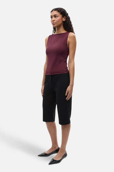 T-shirt sans manches bordeaux d'ENVII, associé à des short de bermuda noirs et des ballerines noires.