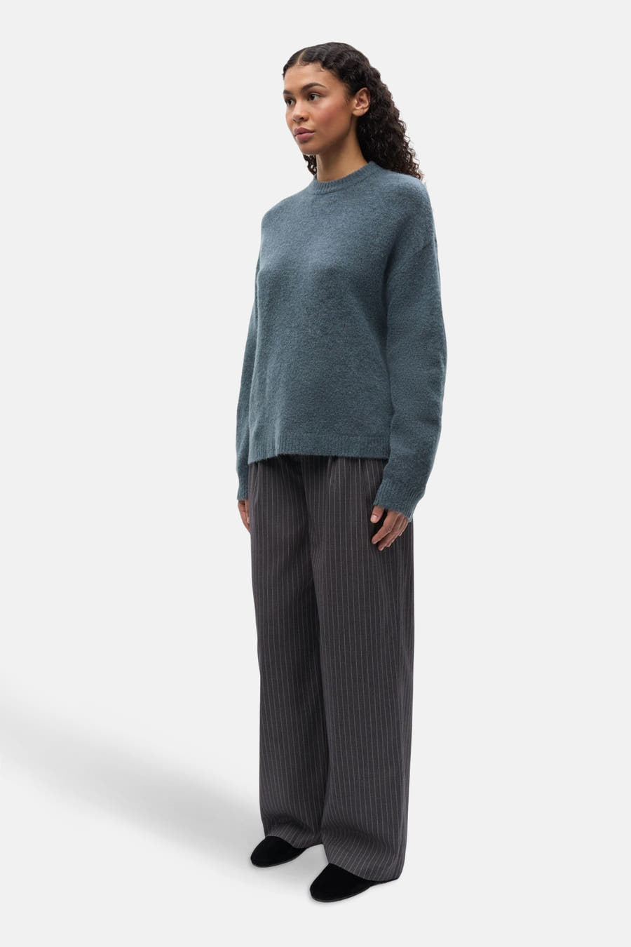 T-shirt bleu avec col rond d'ENVII, à longues manches, associé à un pantalon rayé.