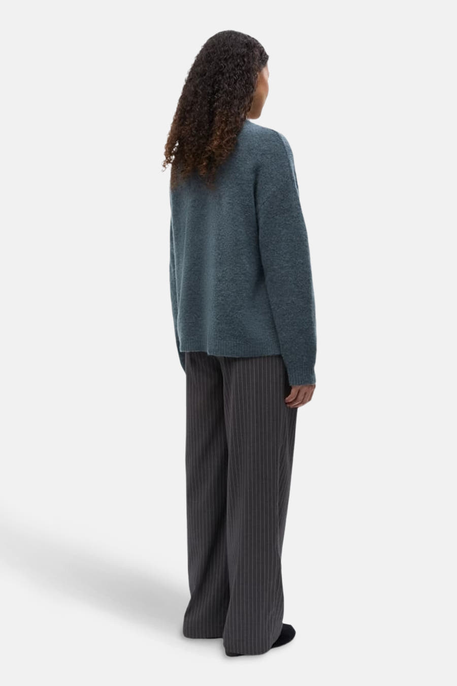 T-shirt bleu avec col rond d'ENVII, à longues manches et porté avec un pantalon rayé.