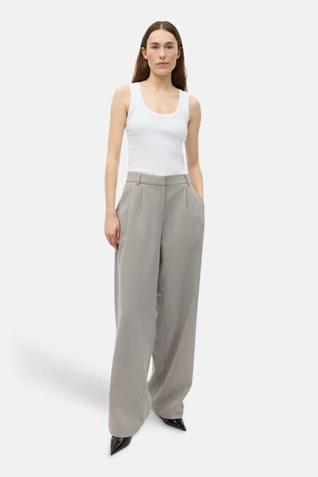 Pantalon beige d'ENVII, avec plis et jambes larges, vue de face.