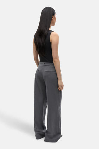 Pantalon gris d'ENVII, avec des jambes larges et des poches arrière, vu de derrière.