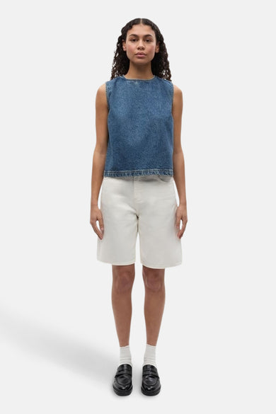 Witte short van ENVII, gecombineerd met een mouwloze denim top, witte sokken en zwarte loafers.