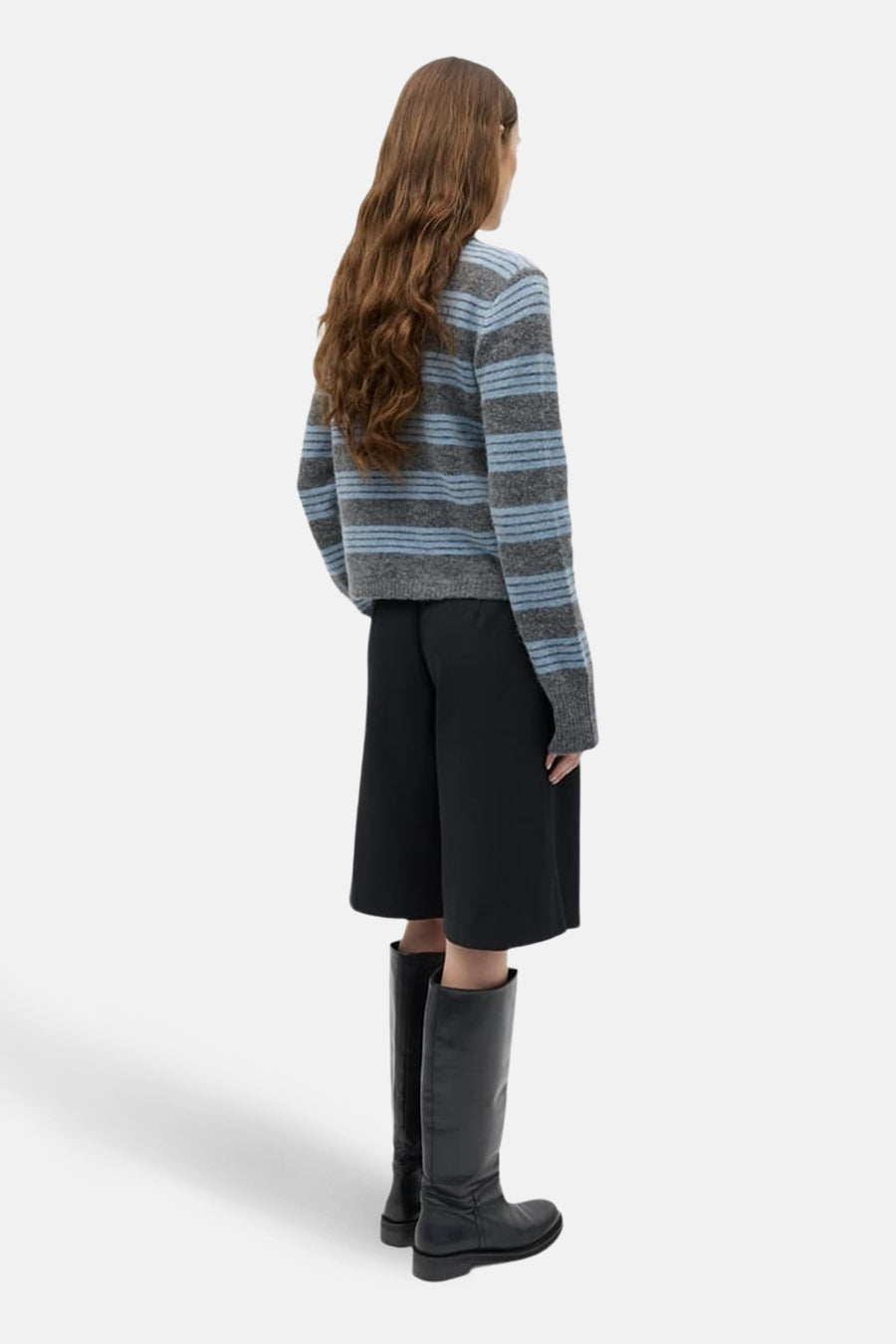 Grijs gilet van ENVII, met een gestreept patroon en gecombineerd met zwarte culotte en zwarte leren laarzen.
