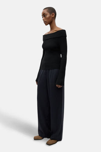 Pantalon bleu d'ENVII, avec des jambes larges et un motif à rayures subtil, porté avec un haut noir sans épaules.