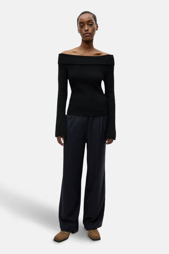 Pantalon bleu d'ENVII, avec une rayure blanche et des jambes larges, associé à un pull noir.