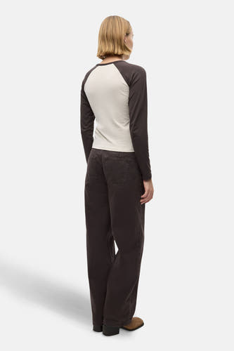 Bruine gekleurde jeans van ENVII, gezien van achteren, met een wijde pijp en gedragen met een beige shirt.