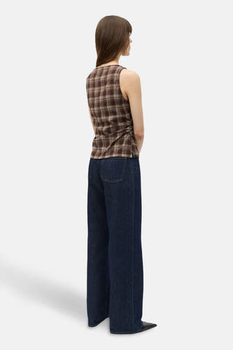 Mouwloze bruine blouse van ENVII, met een geruite print en ruches aan de zijkant, gedragen met een donkerblauwe jeans.