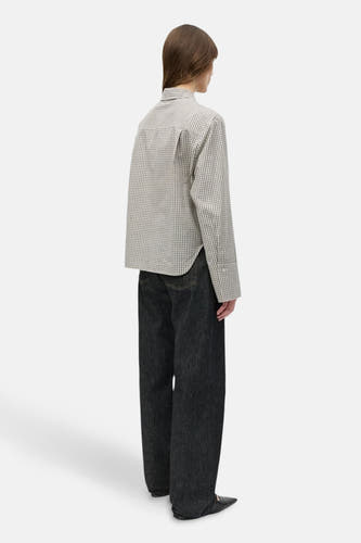 Beige hemd met lange mouwen van ENVII, met een klein geruit patroon, gedragen met donkere jeans.
