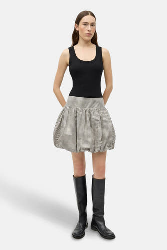Beige korte rok van ENVII, met een geruite print en gedragen met zwarte tanktop en laarzen.
