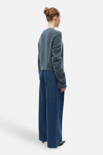 Cardigan bleu d'ENVII, avec des manches longues et porté avec un jeans large.
