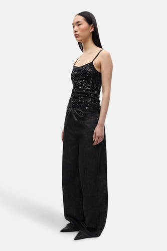Zwarte wijde jeans van ENVII, met trekkoord tailleband en gecombineerd met een zwart pailletten top.