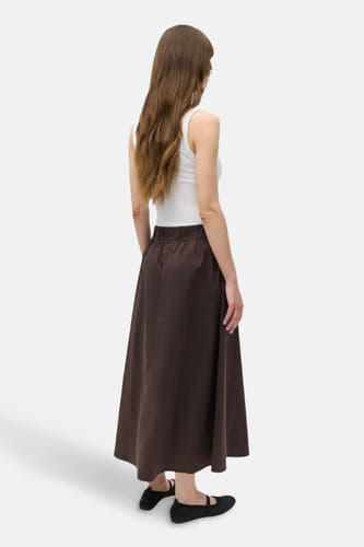 Jupe brune d'ENVII avec une ceinture élastique, associée à un haut blanc et des chaussures noires.
