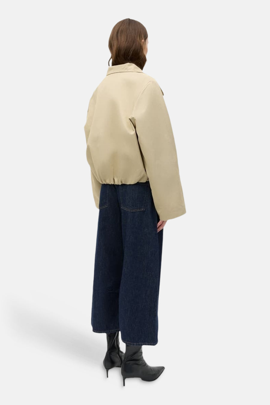 Beige korte jas van ENVII, met lange mouwen, gecombineerd met wijde donkerblauwe jeans en zwarte laarzen.