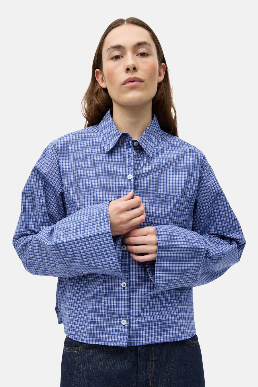 Chemise bleue à manches longues ENVII, à motif à carreaux et fermeture à boutons blanche, portée avec un jean foncé.