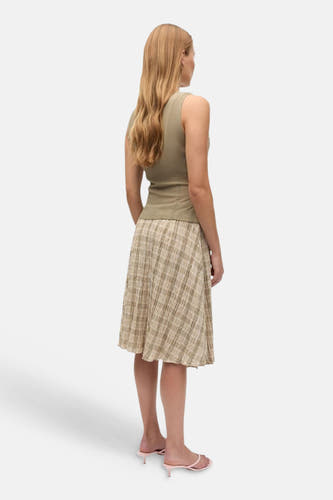 Groene mouwloze blouse van ENVII, achterzijde, met gladde stof en strakke pasvorm, gedragen met geruite rok en roze sandalen