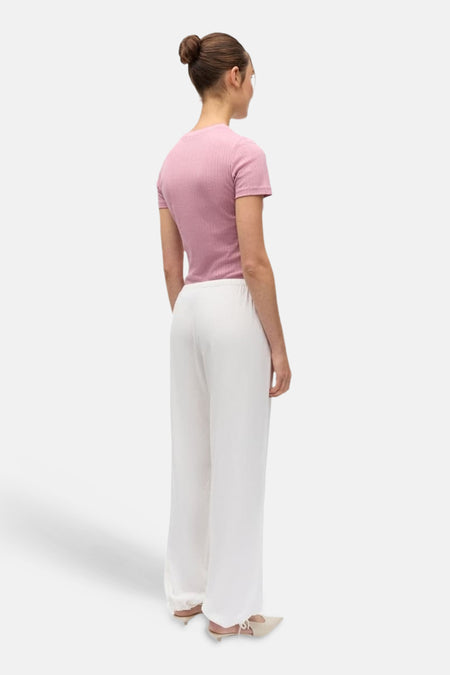 Pantalon blanc ENVII à jambes larges, porté par un mannequin dans un haut rose côtelé, vue arrière.