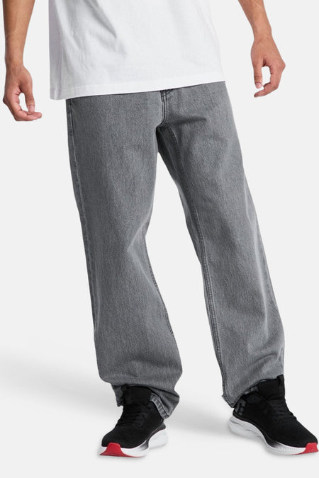 Mid grijze denim jeans met een speciale pasvorm van DC SHOES, gedragen met een wit T-shirt en zwarte sneakers met rode zool.