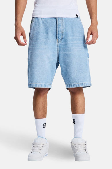 Short en jean denim bleu clair de DC SHOES, avec poches arrière, porté avec des chaussettes blanches et des baskets blanches.