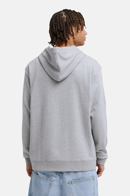 Grijze sweater met kap van DC SHOES, rugzijde met lichtblauwe jeans.
