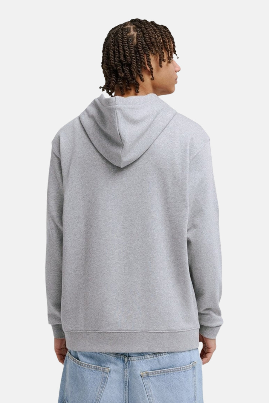 Grijze sweater met kap van DC SHOES, rugzijde met lichtblauwe jeans.
