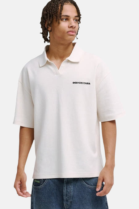 Witte polo van DC SHOES met oversized pasvorm, polokraag, korte mouwen en 'DCSHOECOUSA' borstprint.