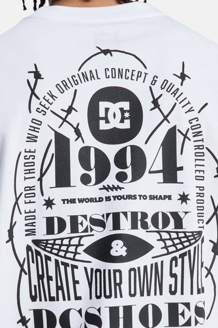 Wit T-shirt met korte mouwen van DC SHOES met een grote zwarte rugprint, inclusief het DC-logo, jaartal 1994, teksten en stekeldraadmotieven.