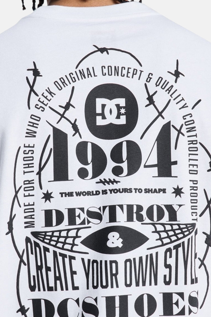 Wit T-shirt met korte mouwen van DC SHOES met een grote zwarte rugprint, inclusief het DC-logo, jaartal 1994, teksten en stekeldraadmotieven.
