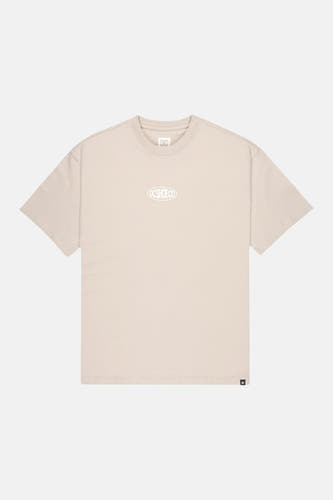 T-shirt beige à manches courtes de DC SHOES avec logo DC SHOE CO blanc sur la poitrine et petite étiquette DC sur l'ourlet.