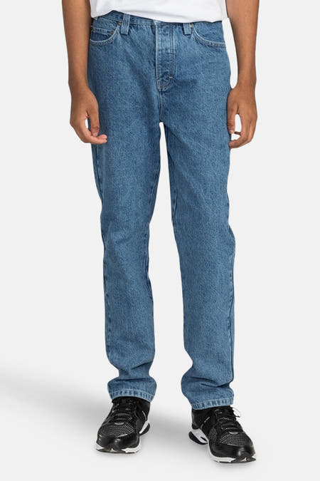 Jean droit en denim bleu d'ELEMENT, avec des chaussures et un t-shirt blanc.